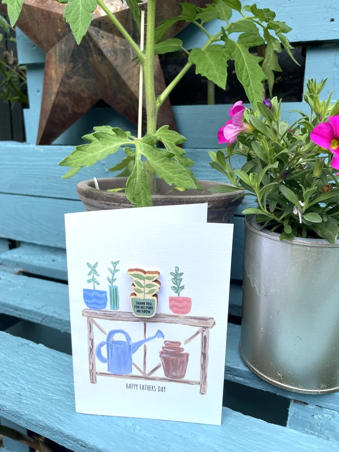 A6 Card with Potting bench illustration. Wooden Pin badge attached .