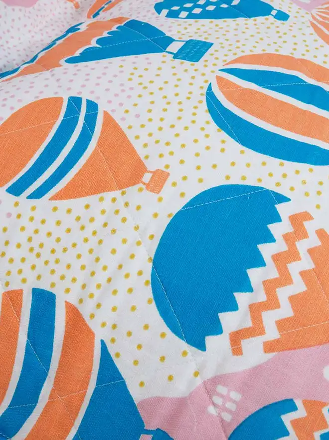 Balloons At Dawn Bean Bag Cover, a colourful bean bag sitting on a floor. 