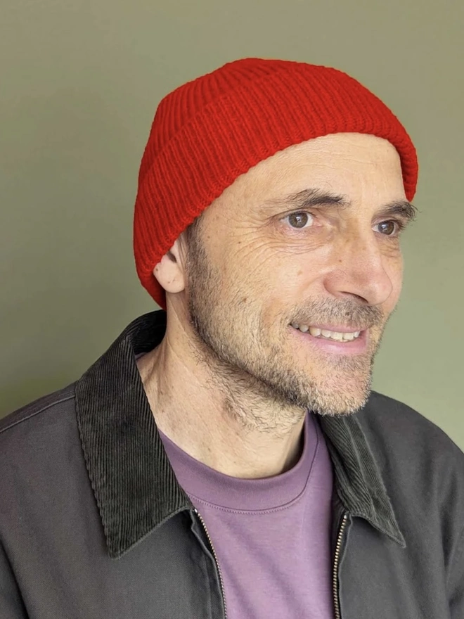 Ribbed Lambswool Men's Beanie, a person wearing a colourful ribbed beanie outdoors. 