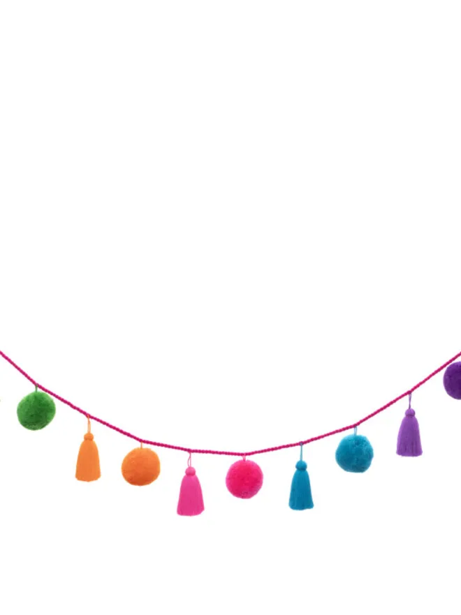 jumbo fiesta pom pom garland. a colourful pom pom and tassel garland hung on a white background.