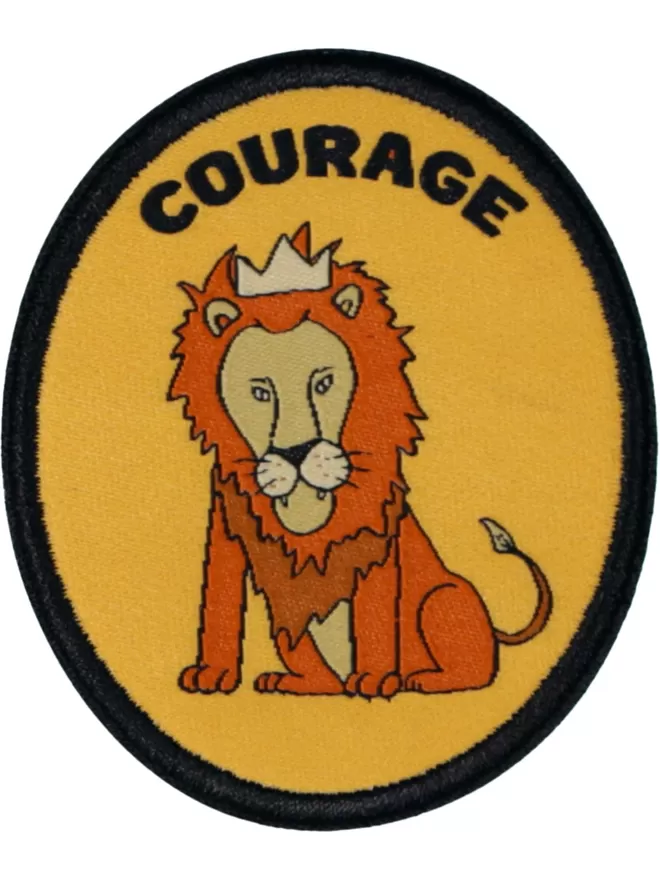 A yellow oval patch. A lion with a crown on his head is seated in the centre. 'Courage' is written above in bold letters.
