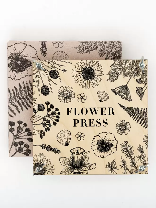Flower press with floral line illustration front, sat on matching retail packaging.