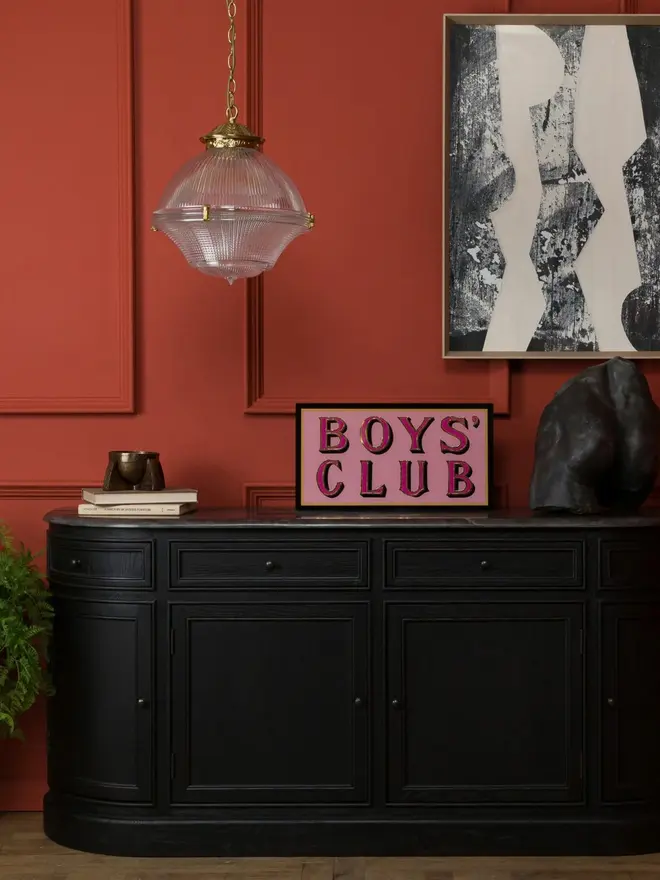boys club pink hand painted sign. sign propped up on mantelpiece.