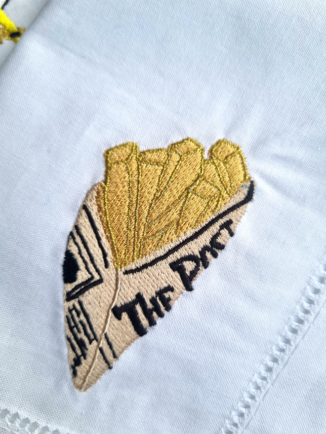 A cone of chips embroidered onto a white napkin