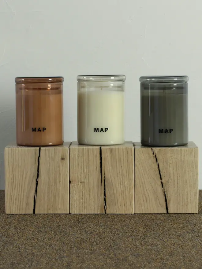 large aromatherapy soy wax candles (set of 3). candles placed on wooden shelf.