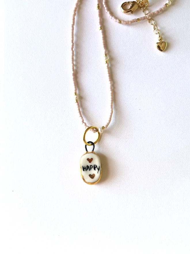 White and gold Porcelain pendant on a delicate pink bead necklace