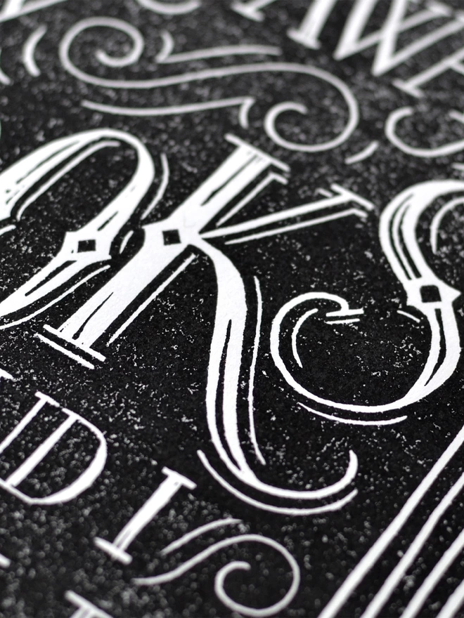 detail of lino cut print lettering in black and white