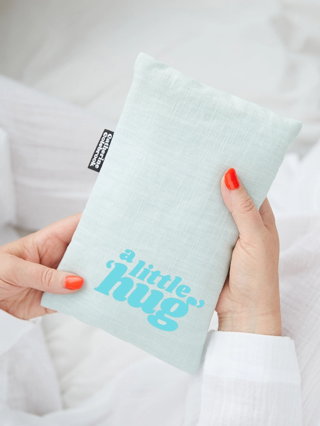 Catherine Colebrook mint linen cute hot water bottle with turquoise 'a little hug' text