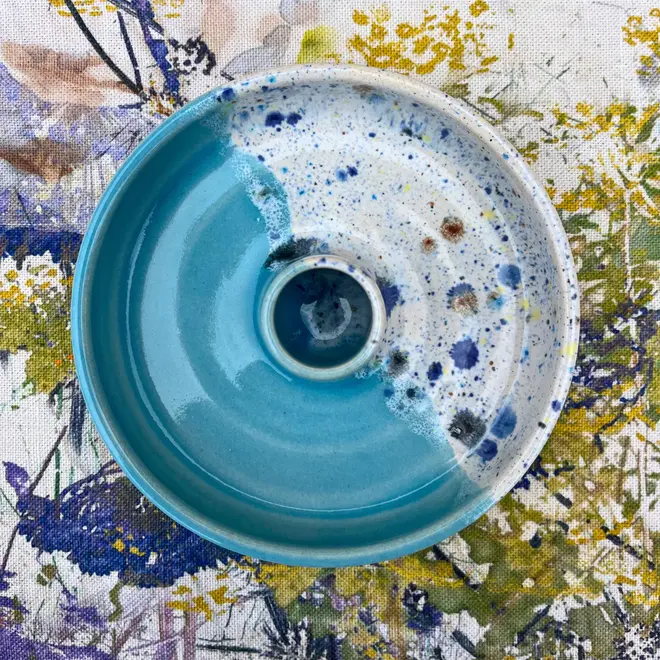 Shoreline Candle Stick Holder, a colourful candle stick holder sitting on a painted surface. 