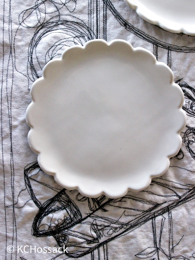 scallope edge white plate on a table