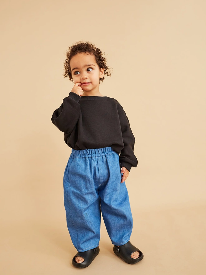 toddler wearing cool denim rounded trousers from childrens shops uk studio koter similar to claude blue denim 