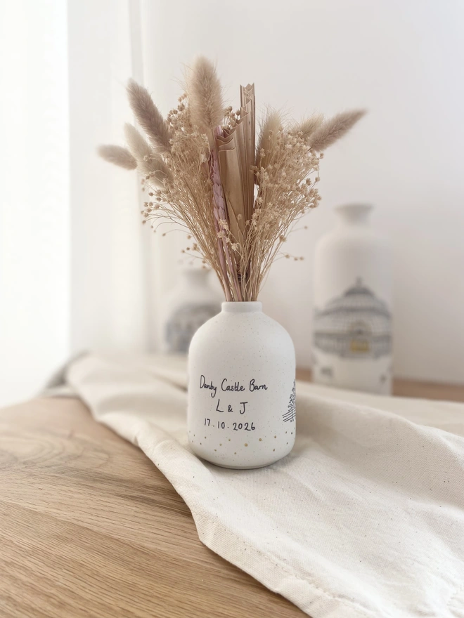 The back of a ceramic vase with black hand written text