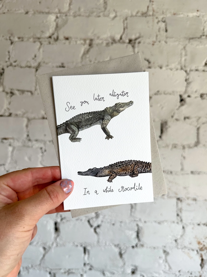greetings card featuring an illustrated alligator and a crocodile and the phrase “see you later alligator, in a while crocodile”