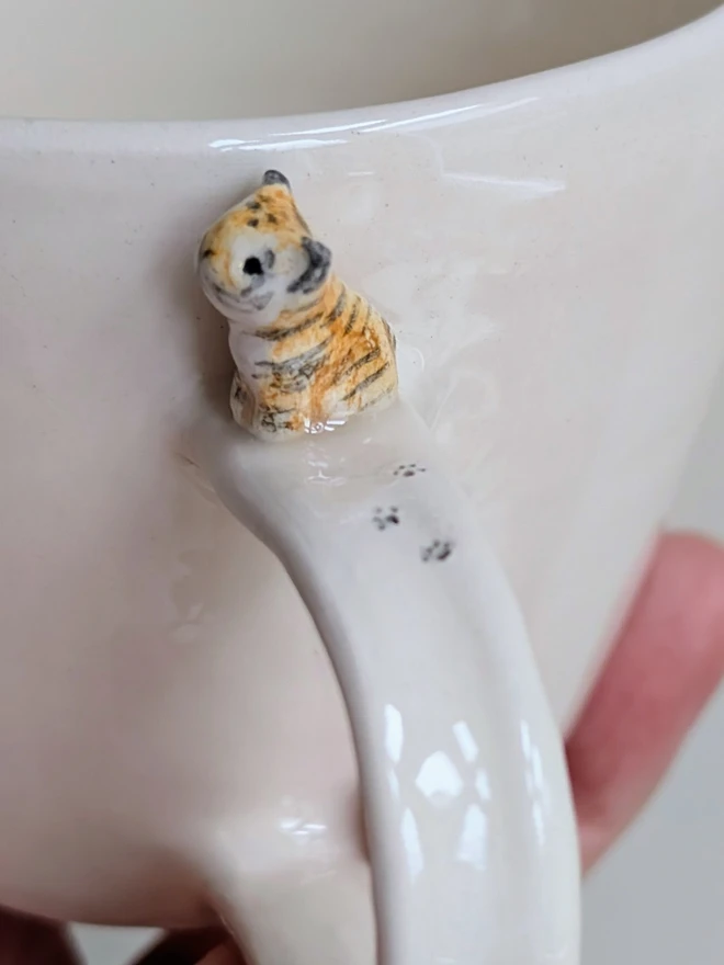 Handmade hello tiger cup in white earthenware ceramic with a tiny stripy cat and hand painted words