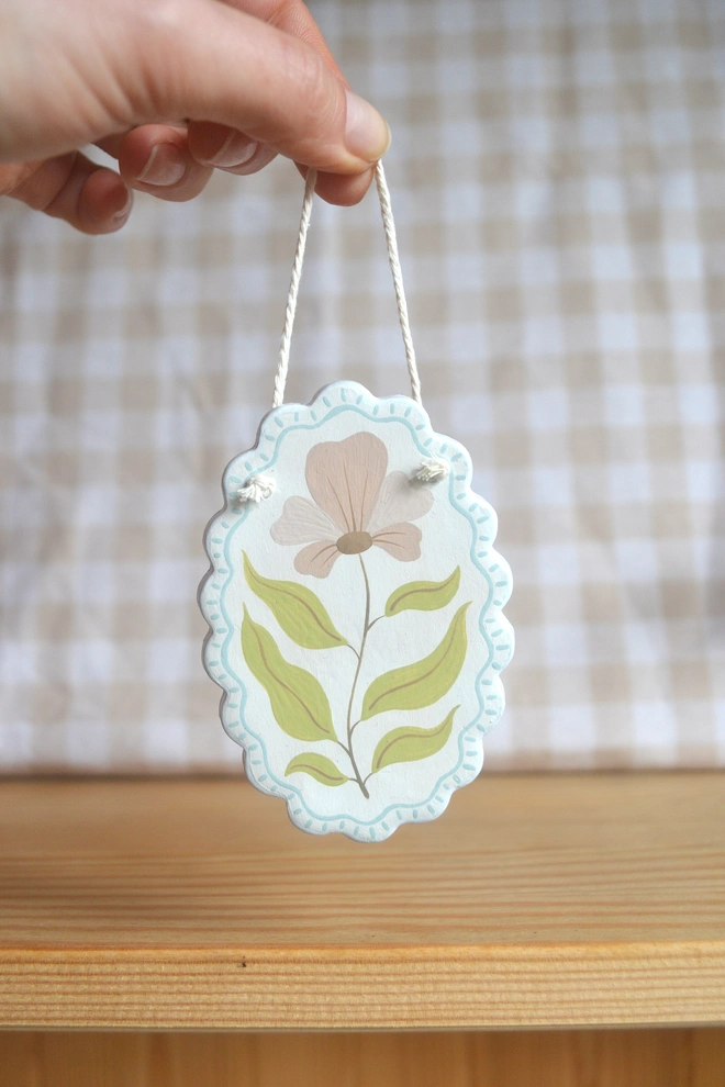 hanging ceramic ornament with blue border and pink an green flower