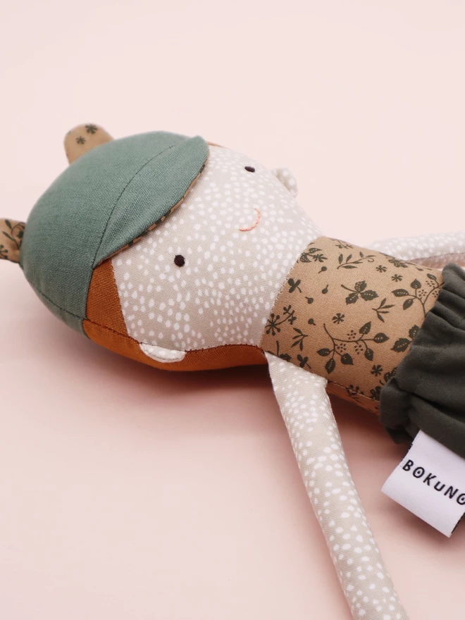 freckled boy doll with green bap with bear ears