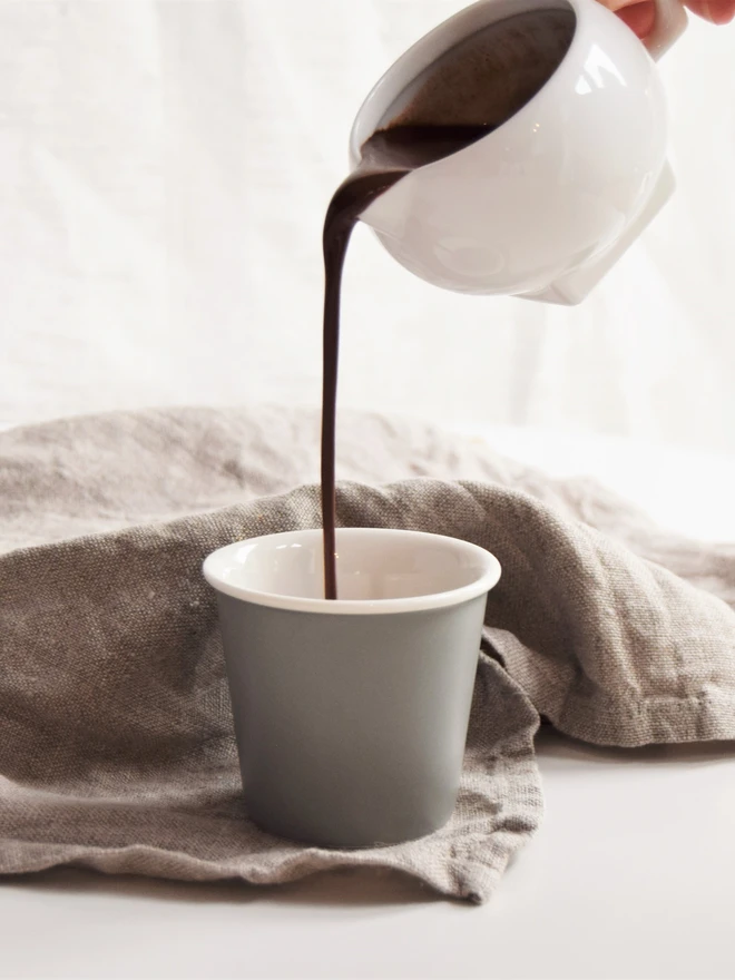 Pouring jug of vegan-friendly hot chocolate into cup