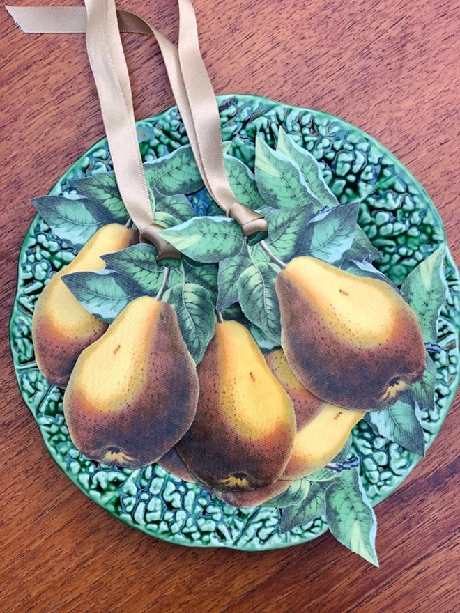 A set of festive table decorations of golden pears for place settings, on a cabbageware plate