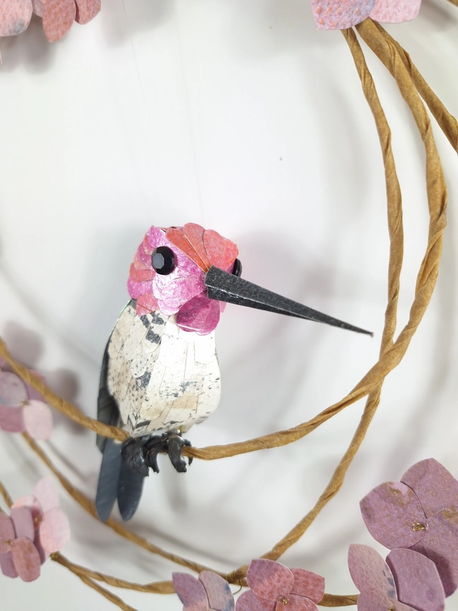 close up of Anna's hummingbird sculpture, made from paper