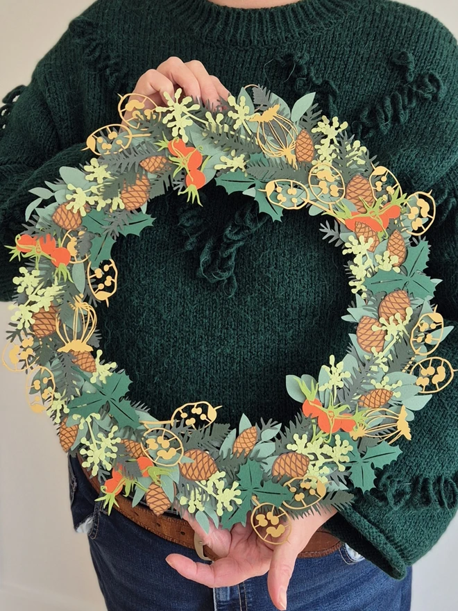 Papercut wreath held in Rosie's hands