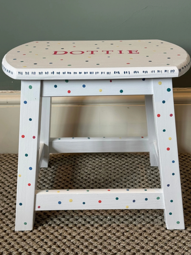 ‘Dottie’ Children’s Hand-Painted Step Stool. A white step stool with multicoloured dots. 