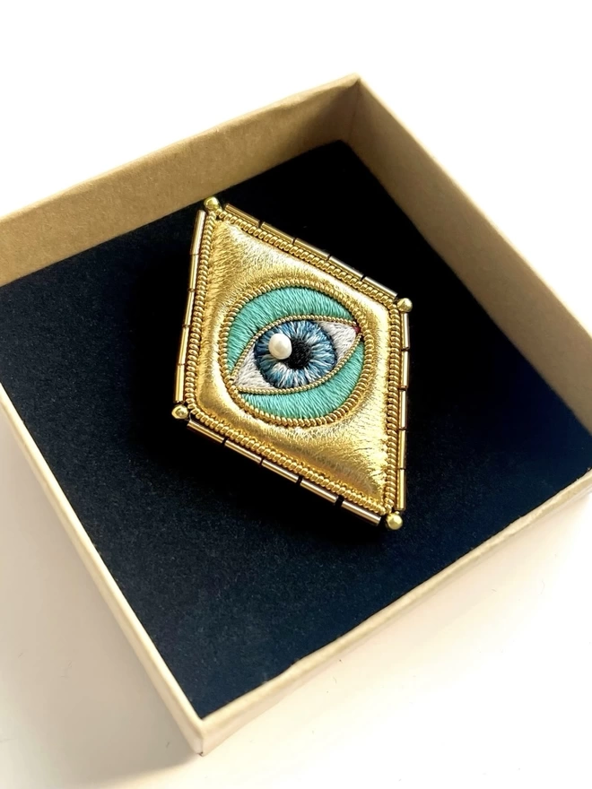 Golden eye brooch green in box