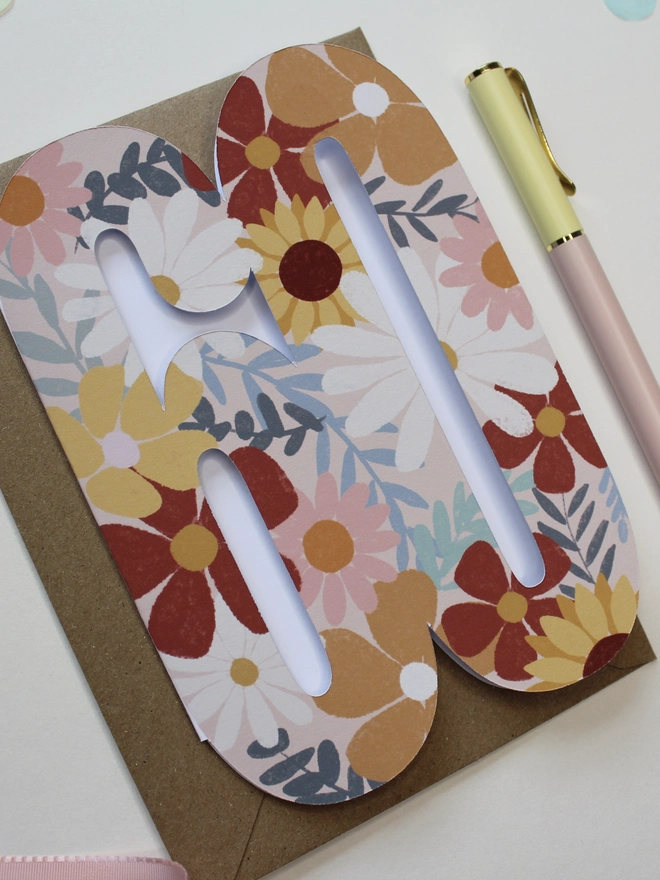 floral 60th birthday card. card shaped like 60 adorned with illustrated flowers.