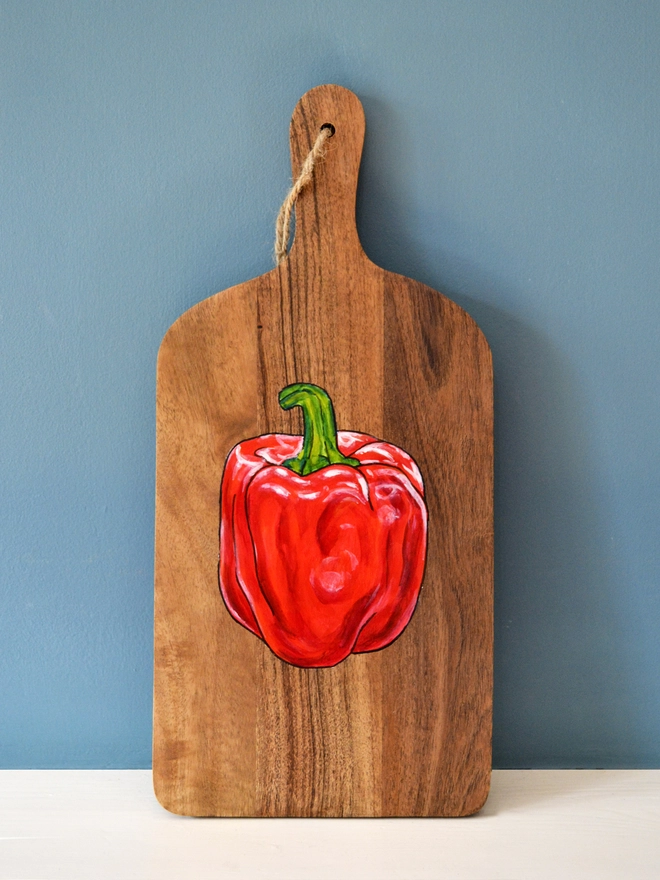 Wooden serving board with handpainted red pepper design
