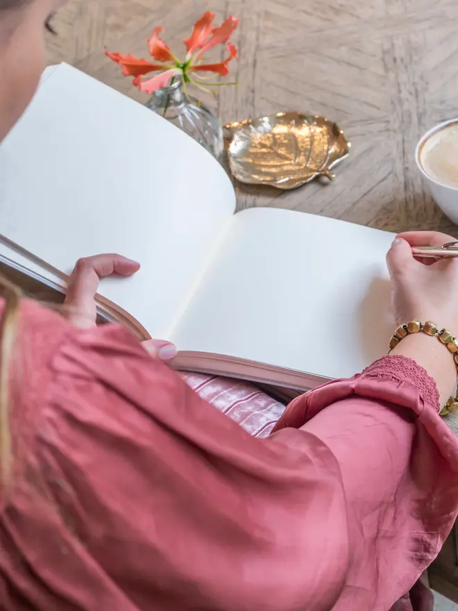 Personalised Calligraphy Font Wedding Guest Book, being written in by a woman.