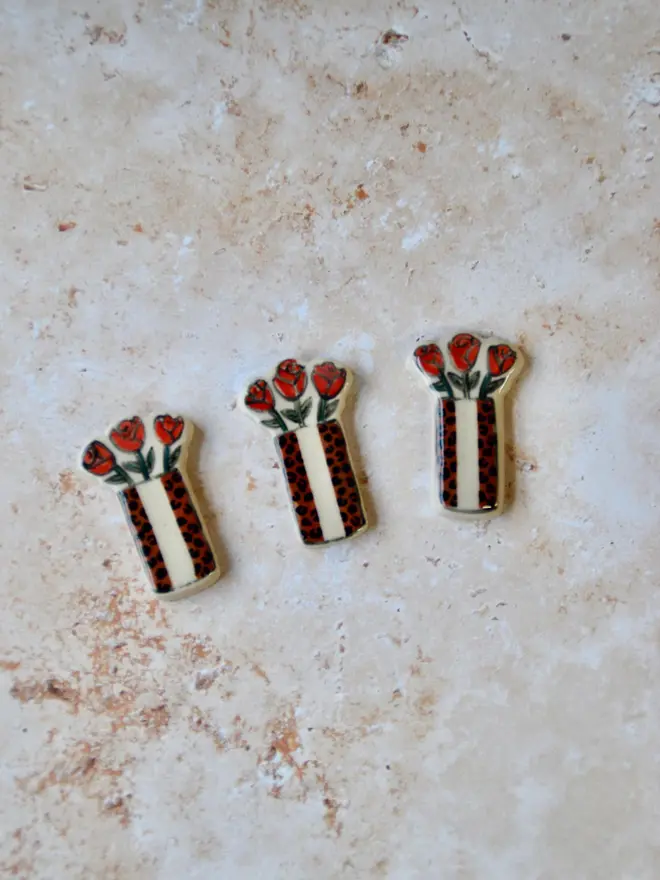 Handmade ceramic candlestick magnets — close-up of red and leopard colourways