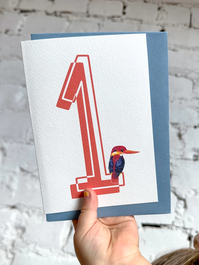 a white card with a big red number 1 and an illustration of an oriental kingfisher with a blue envelope