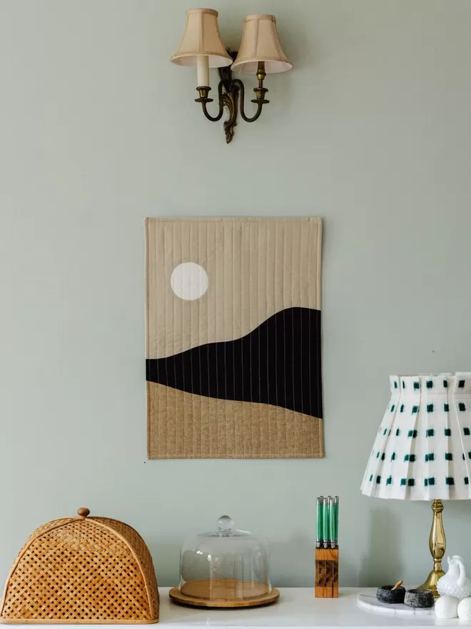 Moonrise Quilt Hanging On Wall Above Table