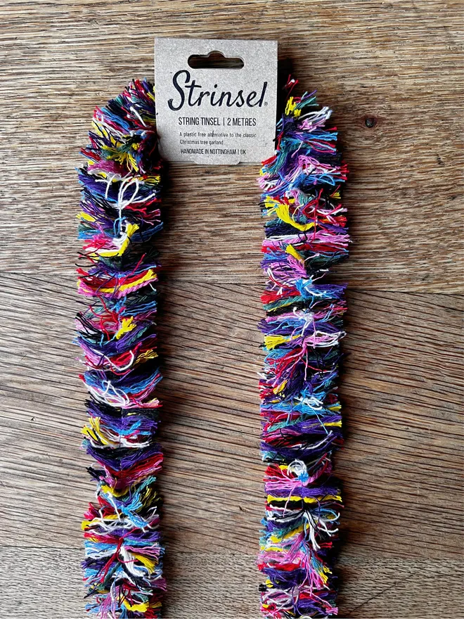 Rainbow Strinsel string tinsel with kraft label on an oak table