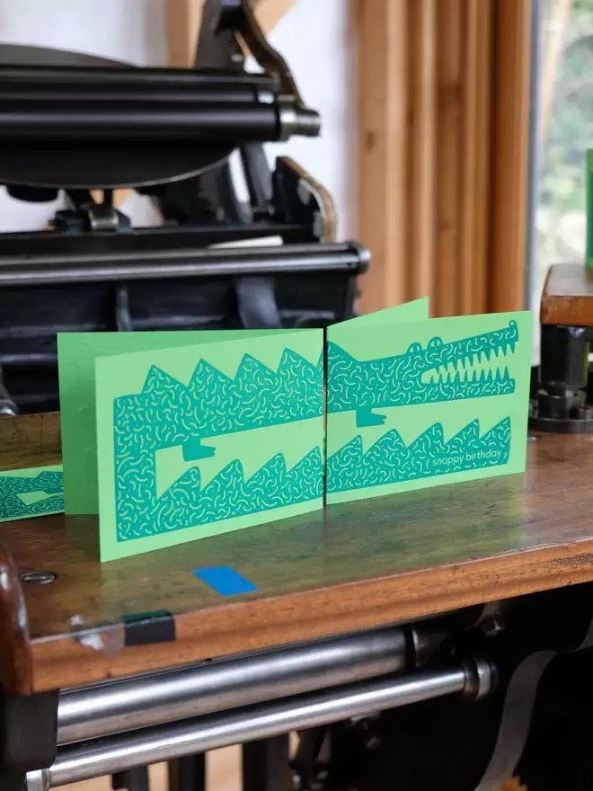 Crocodile illustrated card, letterpress printed, green ink on green card.