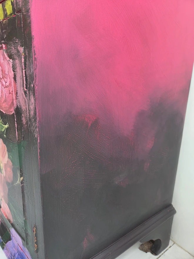 Side view of painted vintage wooden cabinet with pink, blue and floral decoration