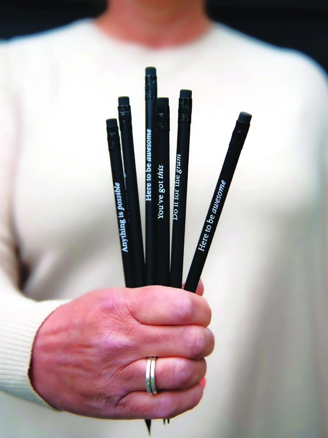 Someone holding a bunch of motivational quote pencils in their hand