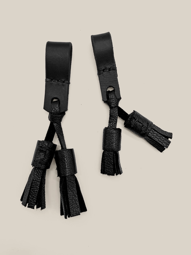 2 black leather dog collar tassels