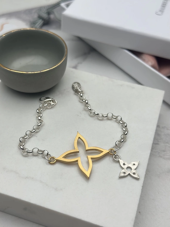 Large gold plate flower charm on silver belcher chain bracelet, with small starling silver flower charm