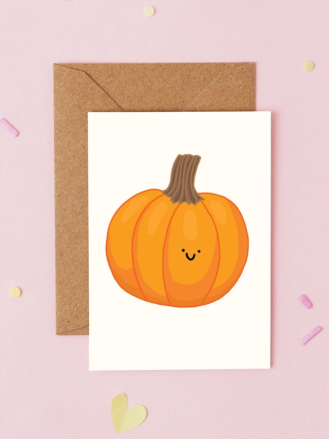 Hand drawn mini Halloween and autumn greeting card featuring a smiling orange pumpkin on a cream background. Cute pumpkin mini card by You've Got Pen On Your Face.