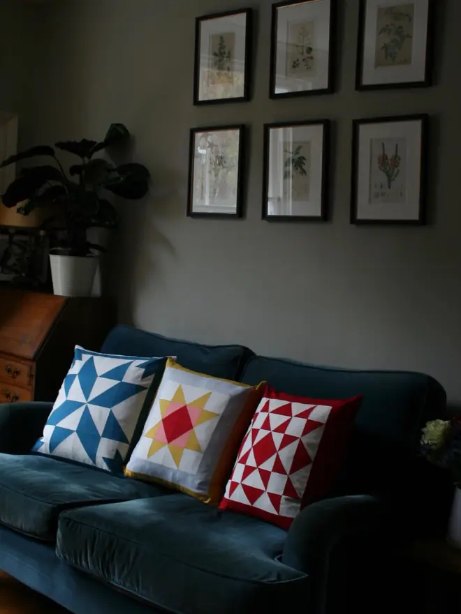 Warm Hearth Patchwork Cushion, on a sofa. 
