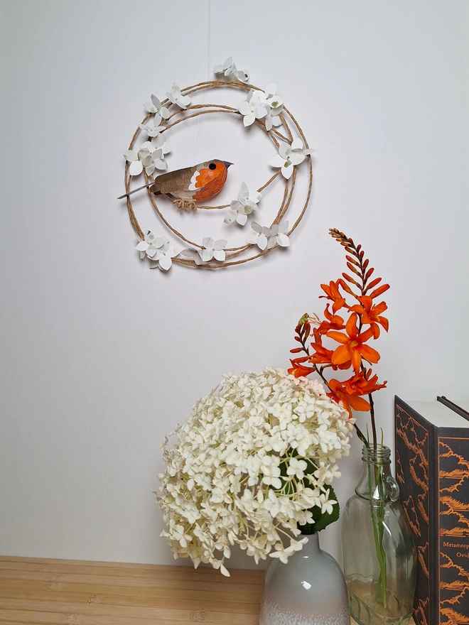 handmade robin sculpture perched on a floral wreath