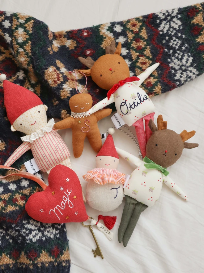 Brown linen gingerbread man christmas tree ornament with a letter hand embroidered in candy cane colours, star shaped sequin, crochet cotton lace around the neck, smile embroidered in white and candy cane colour string to hang. 