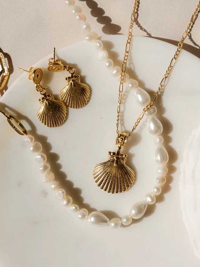 Gold vermeil shell pendant with matching shell earrings and pearl hammered chain on white background