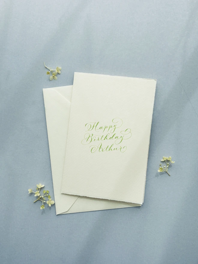 Simple calligraphy birthday card with envelope behind it