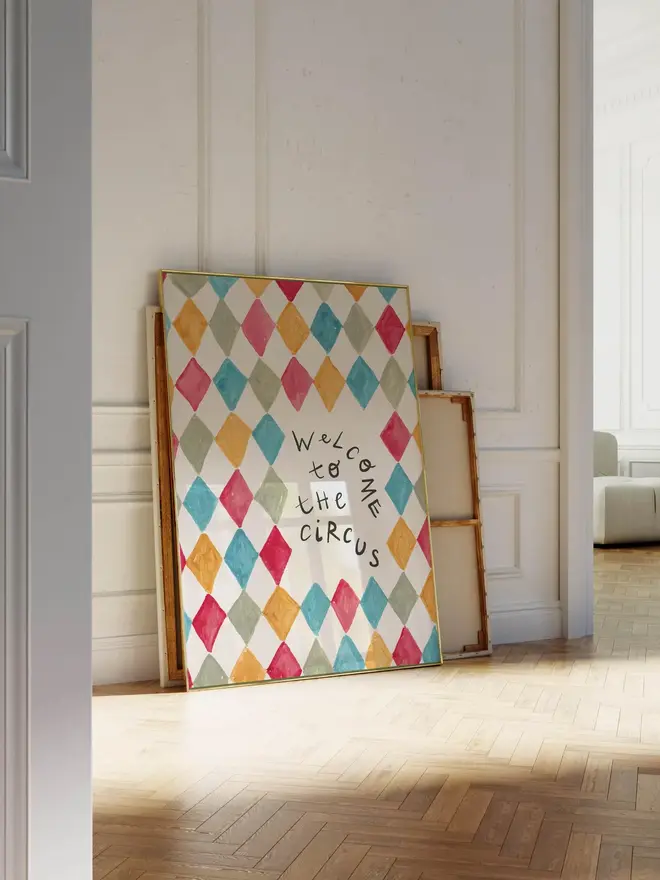 'welcome to the circus' art print. a print with a colourful diamond pattern background and a slogan in black letters. 