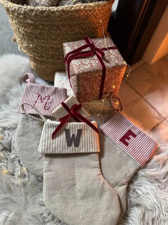 Striped Mini Christmas Stocking. Three stockings on a furry rug with wrapped gifts