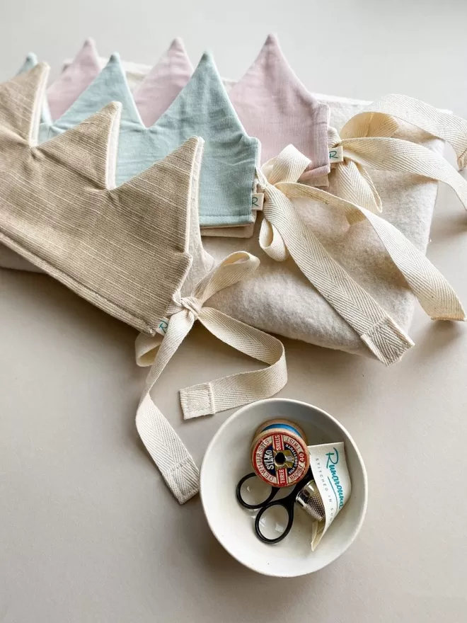 Old Gold  Dressing up Crown seen with a blue and pink crown upon a cotton gifting bag.