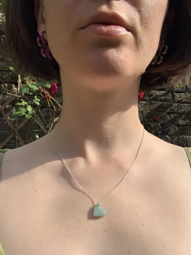 Recycled fishing net heart of a silver chain, necklace shown on a white women