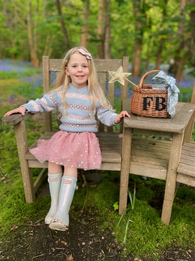 child sitting on seat with personalised basket on table