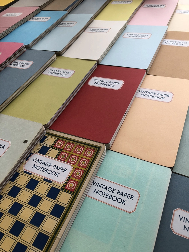 An assortment of vintage paper notebooks showing the colours and patterned covers available